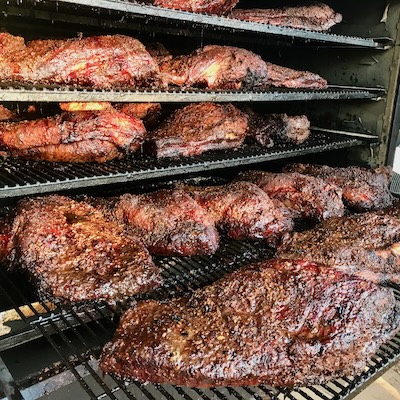 picture of many briskets in a smoker